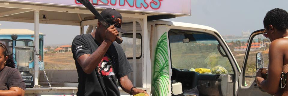 Guy chopping a cocnut with a machete